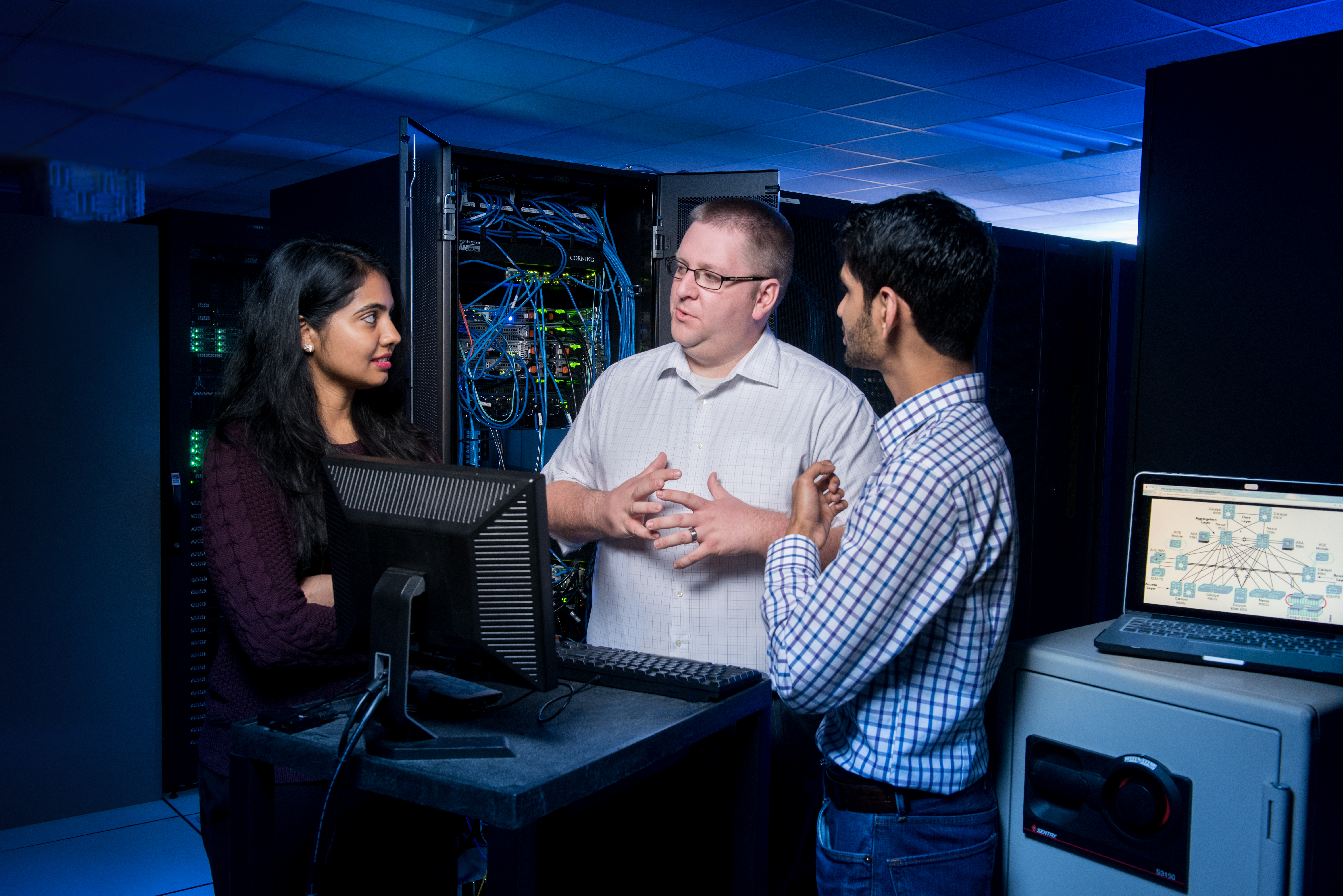 3 students discussing around a computer.
