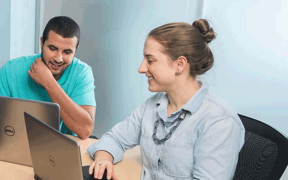 Woman and Man chatting looking at a laptop